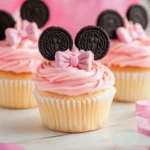 Cute Minnie Mouse Cupcakes decorated with pink frosting, Oreo cookie ears, and fondant bows, perfect for Disney-themed parties.
