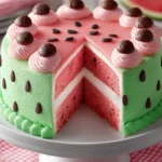 Watermelon cake recipe with layered pink sponge cake and green frosting decorated like a watermelon, topped with chocolate chip seeds