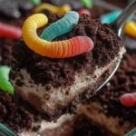 Dirt cake recipe with crushed Oreos and gummy worm topping served in a glass dish